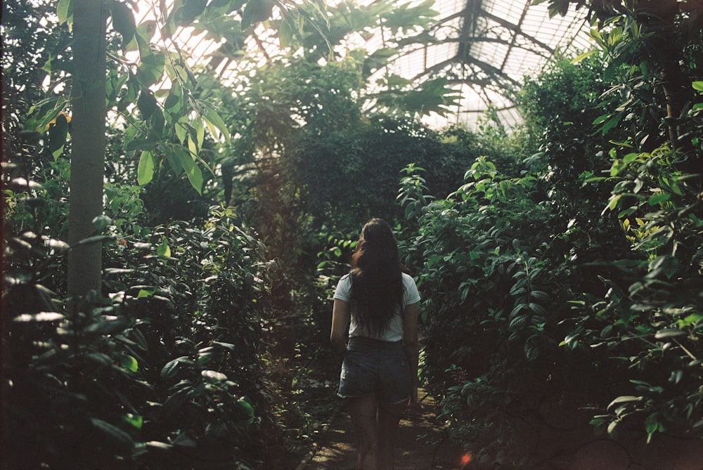 woman walking inside greenhouse