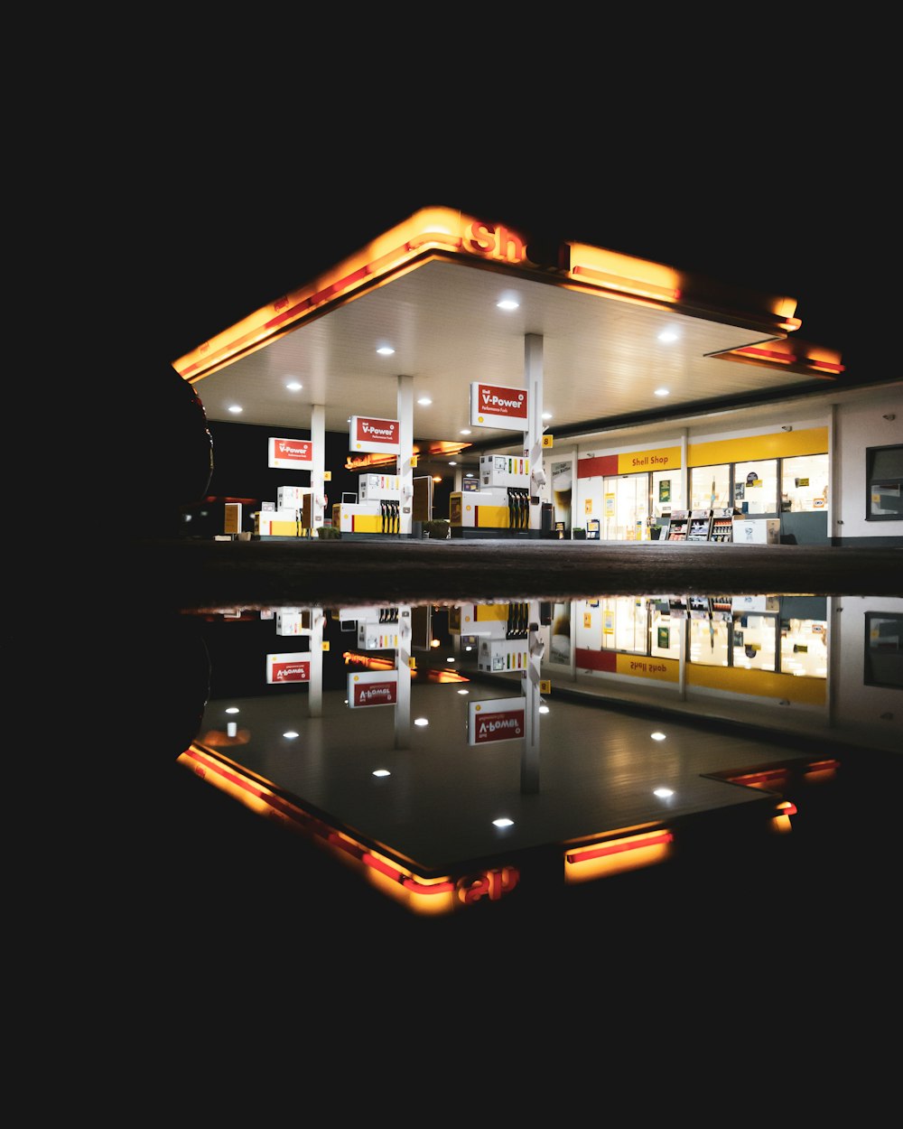 a gas station with a reflection in the water