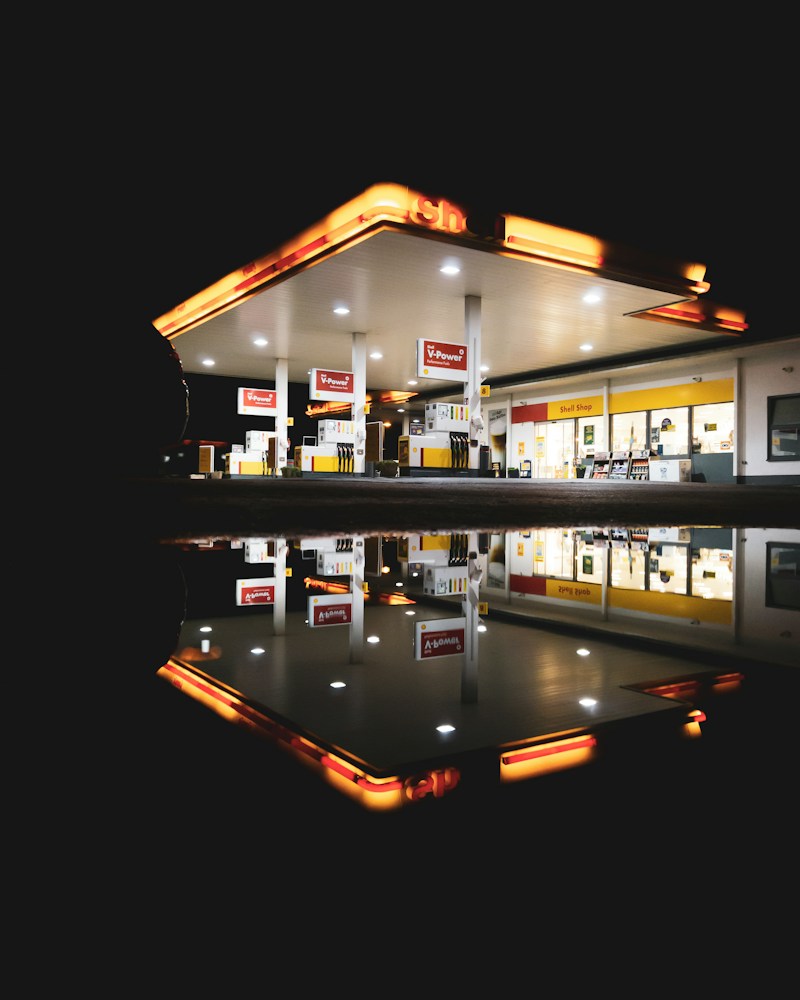 Modern gas station at dusk with illuminated canopy