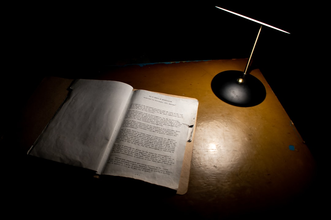 open book beside black table lamp