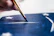 Close-up of a painter carefully applying bright paint to a cozy Clarksville home's exterior.