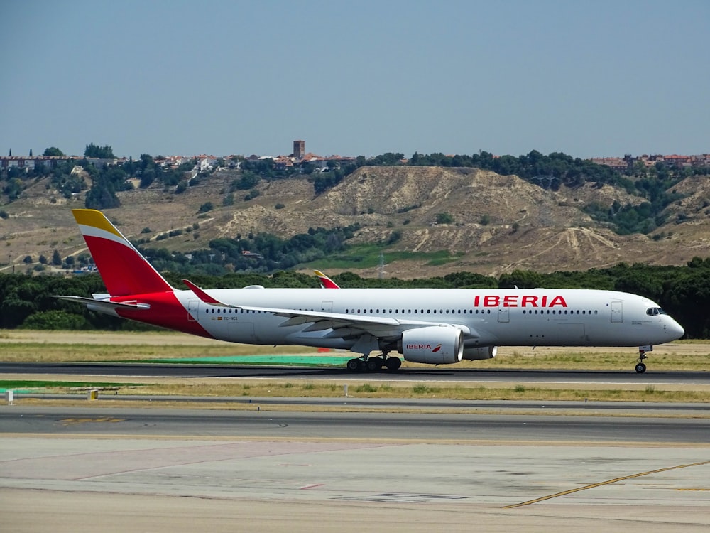 Avión blanco y rojo de Iberia en el aeropuerto
