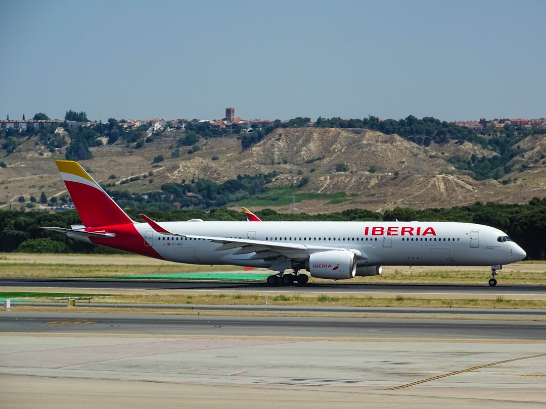white and red Iberia plane on airport,