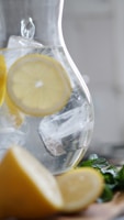 sliced lemon inside pitcher with ice cubes