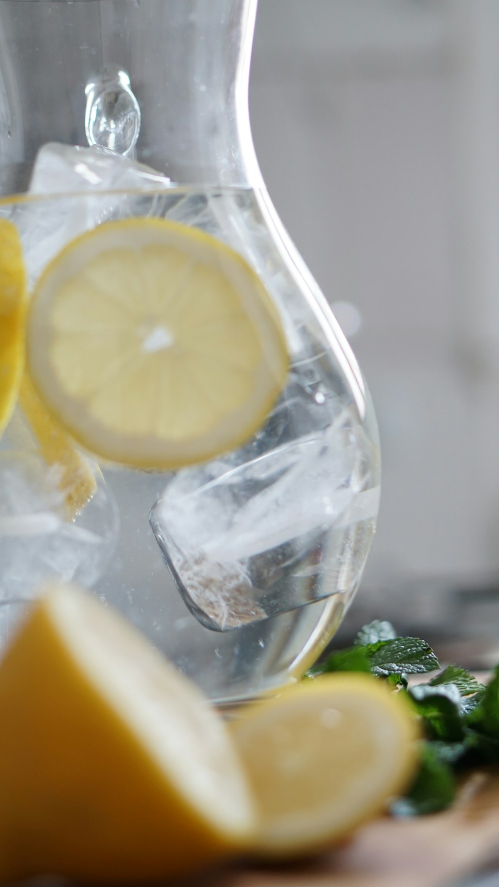 sliced lemon inside pitcher with ice cubes