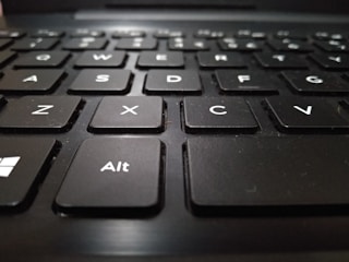 A close-up view of a black keyboard with white letters, focusing on the keys with letters A, S, D, F, Z, X, C, V, and the Alt key.