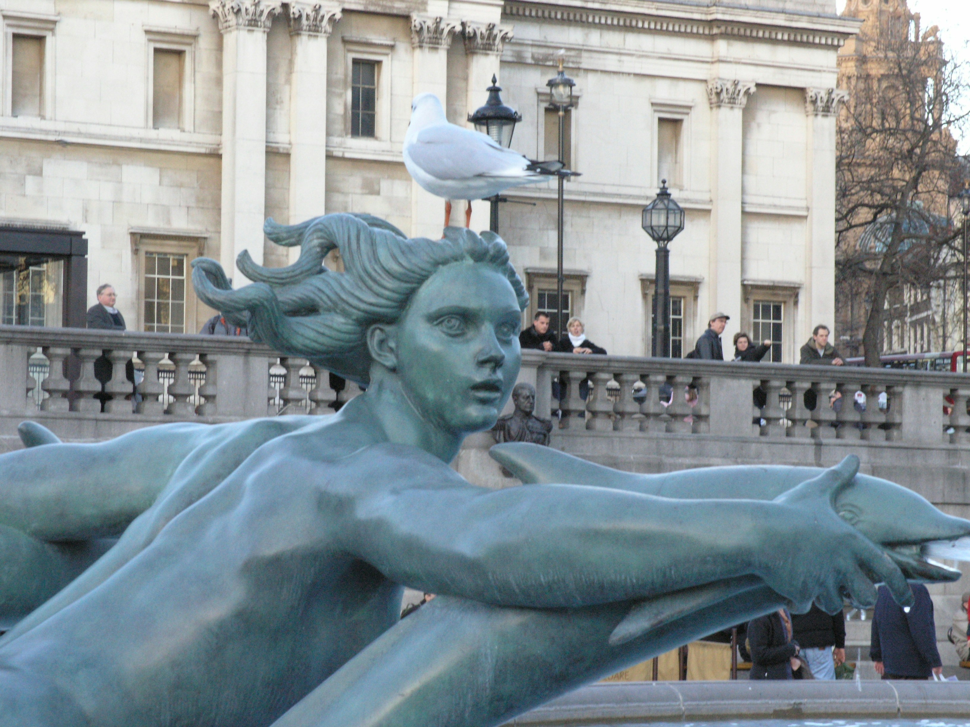 woman holding gray dolphin statue