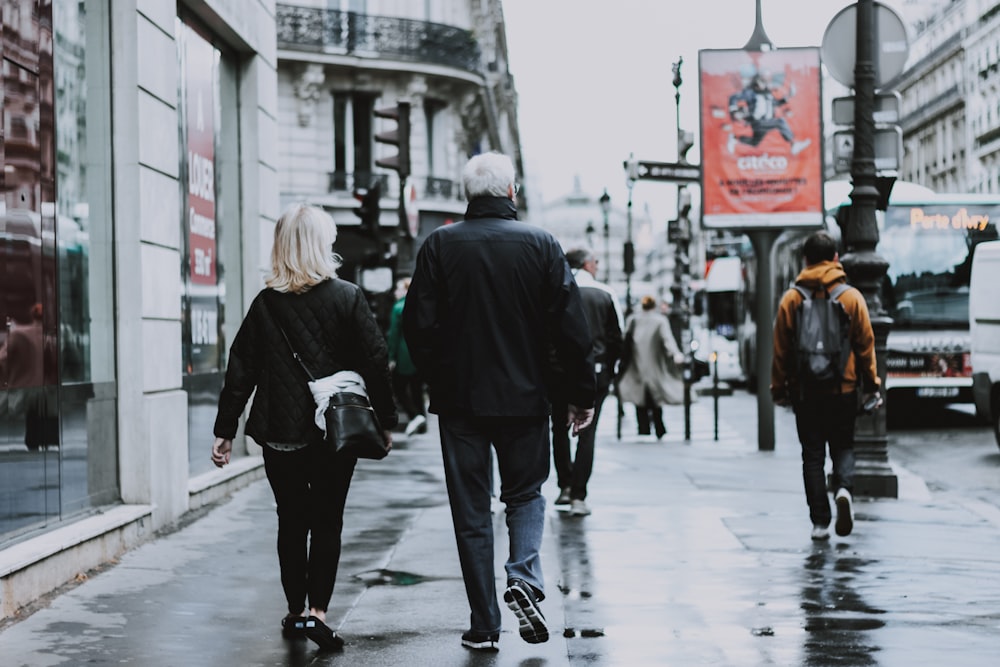 male and female couple walking in wet sidewalk