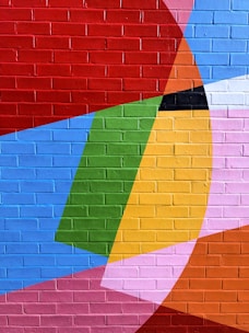 A vibrant mural painted on an urban wall featuring bold colors and abstract shapes.