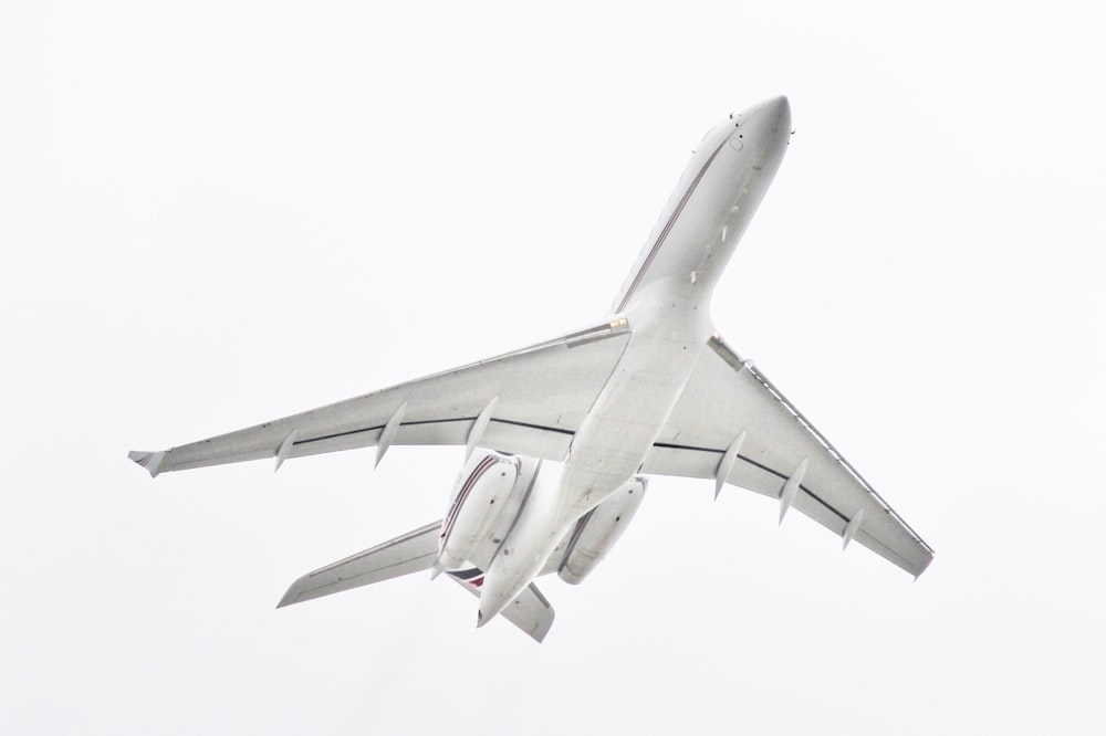 white passenger plane passing overhead