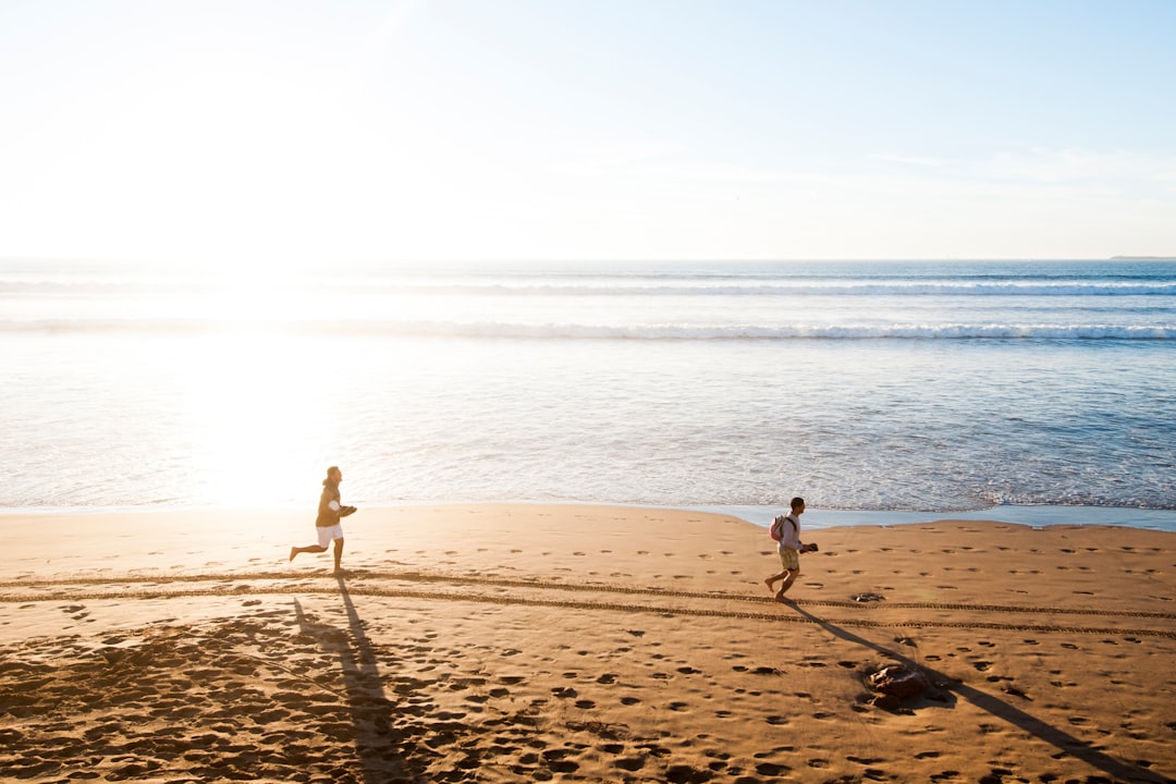 man chasing child in beach