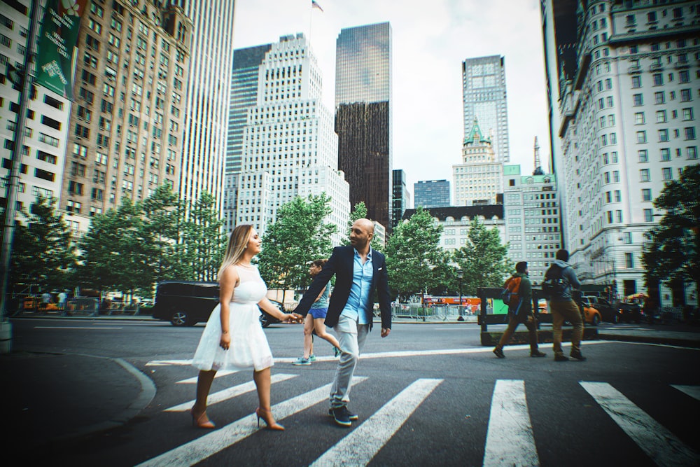 uomo e donna che attraversano la strada mano nella mano