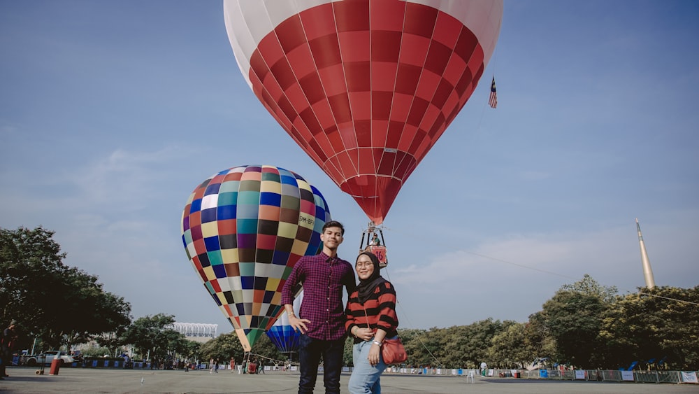 man and woman standing near hot air balloon