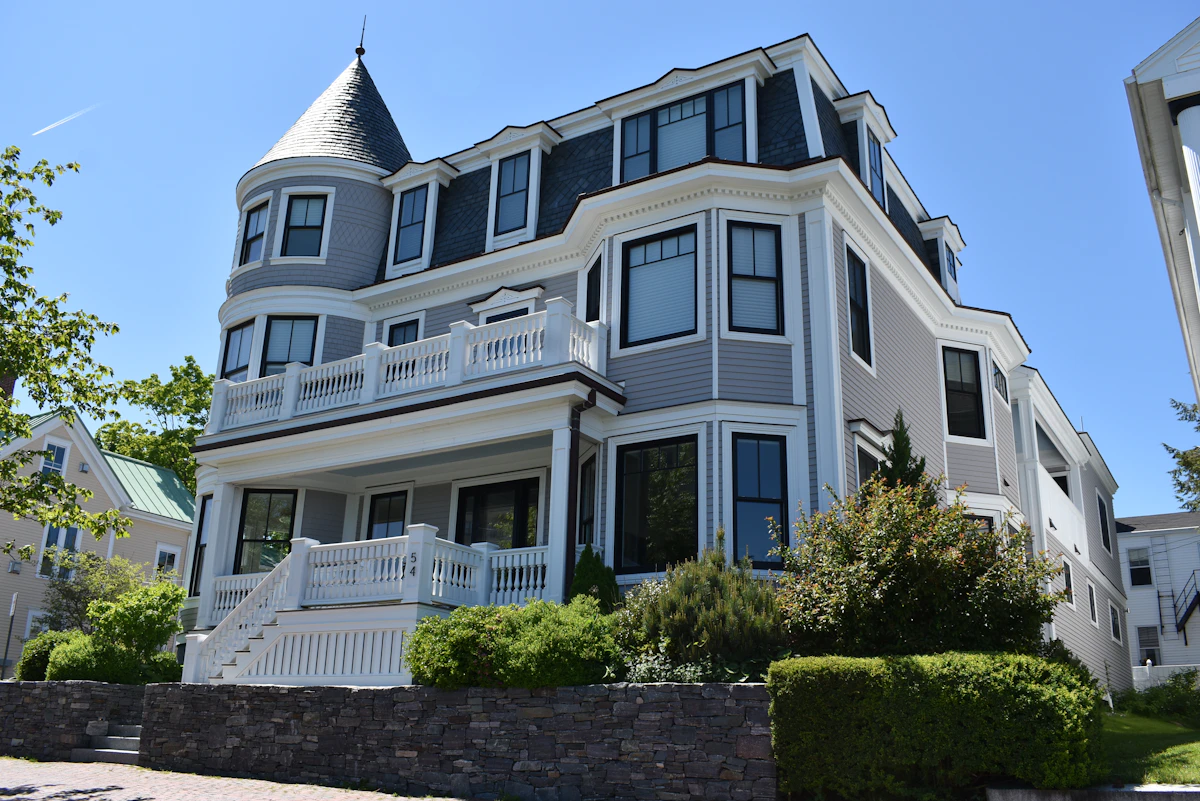 A large grey shingle-style house with a turret