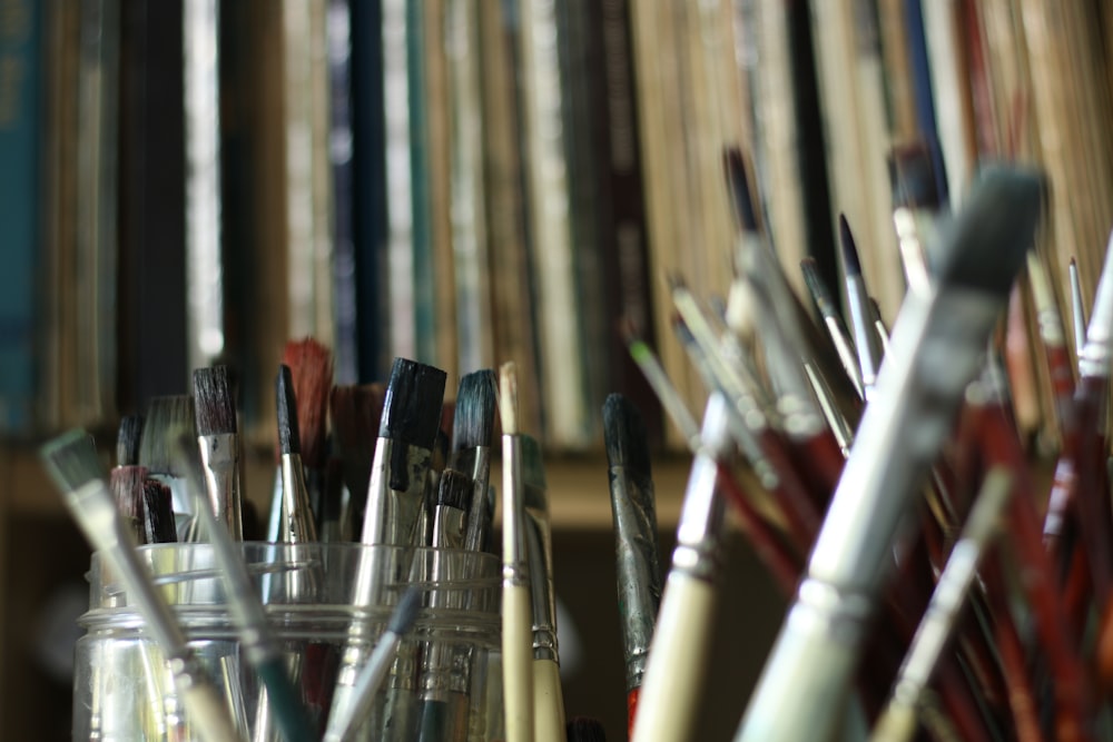 a bunch of paint brushes are in a jar