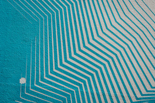 A striking geometric pattern mural on a modern home interior wall.