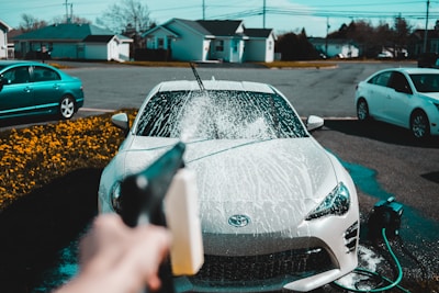 person spraying water on vehicle