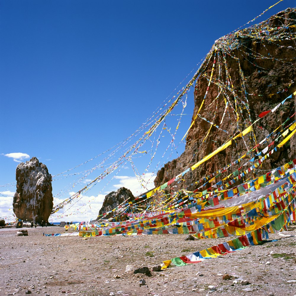 flaglets hanging on rock formation during daytime