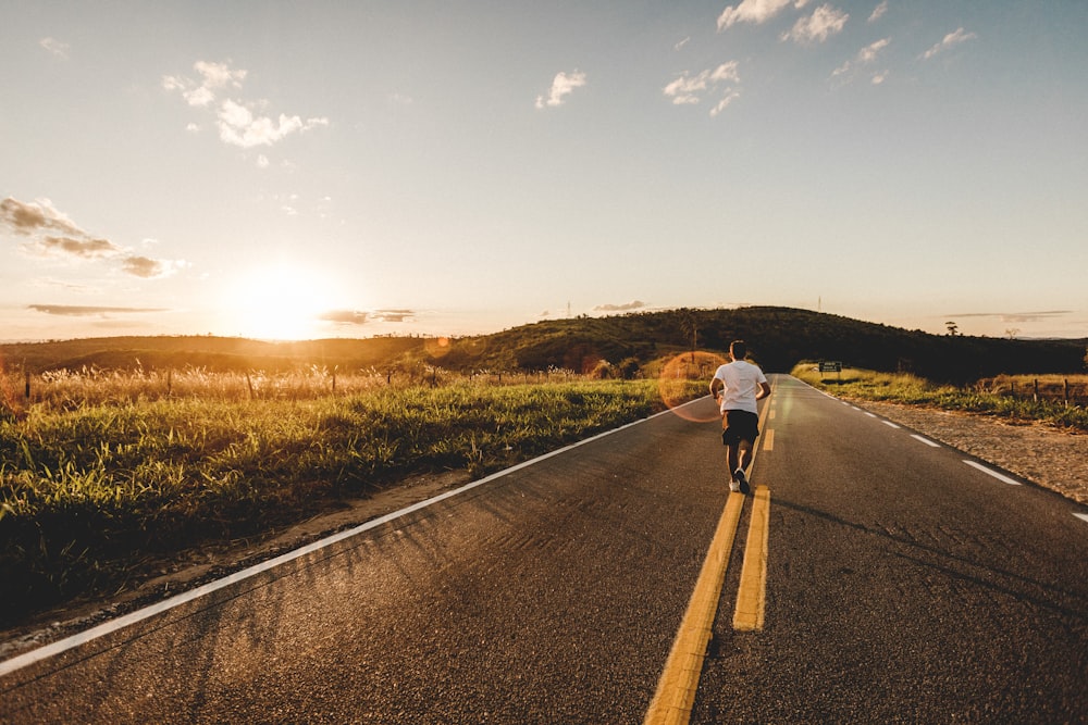 Persona que corre en la carretera durante el día