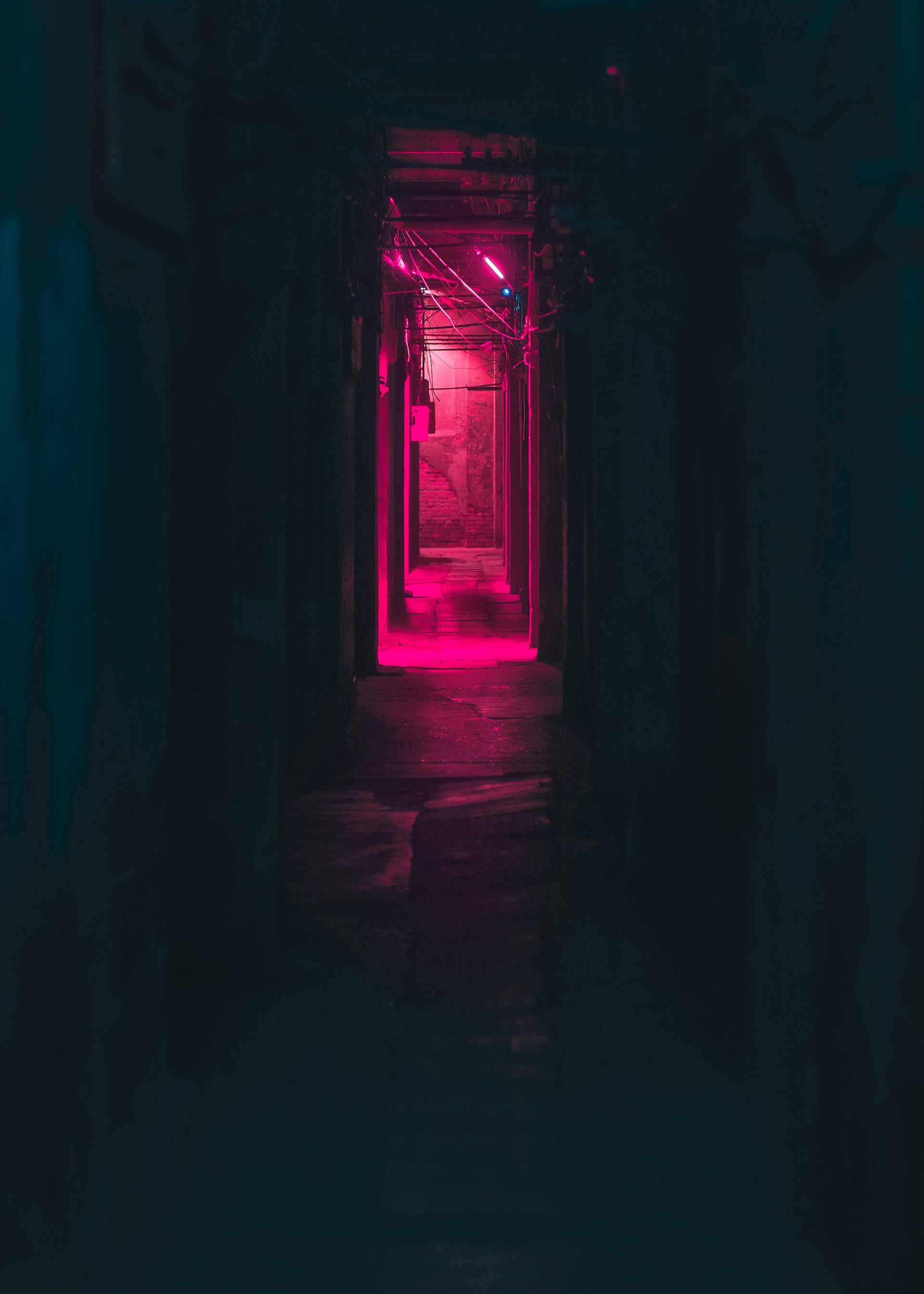 a dark hallway with a red light at the end
