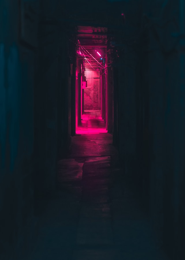 a dark hallway with a red light at the end