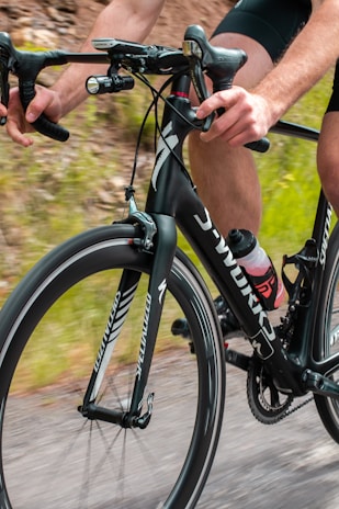 Cyclist gripping handlebars, sporting snug and breathable ankle supports designed for endurance rides.