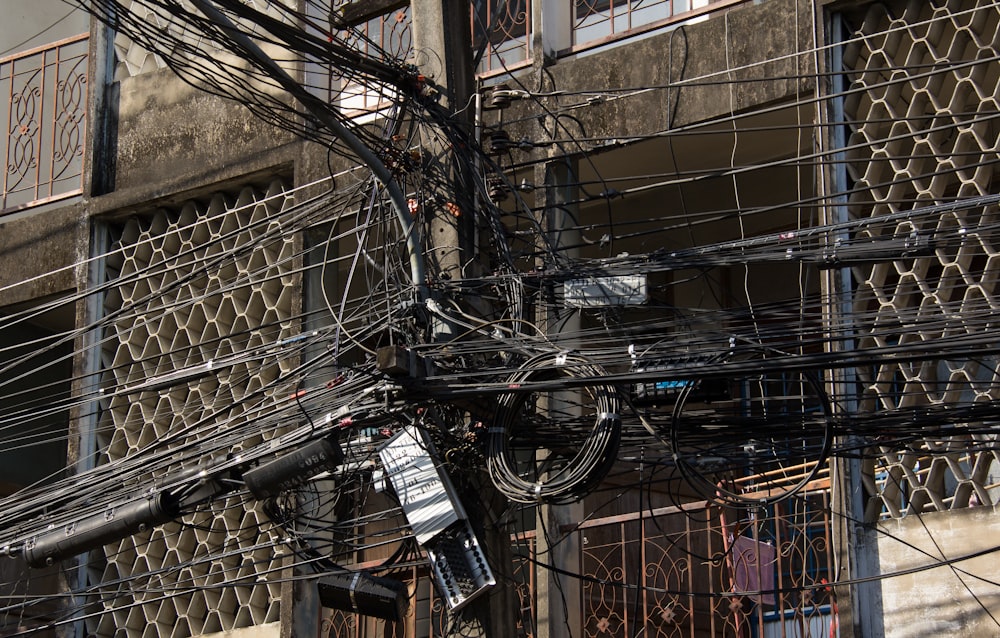 Un montón de cables y alambres colgando de un edificio