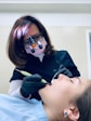 A dentist gently examining a patient’s teeth in a bright, clean clinic setting.