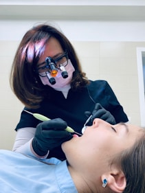 A friendly dentist gently examining a young patient's teeth in a bright, welcoming clinic.