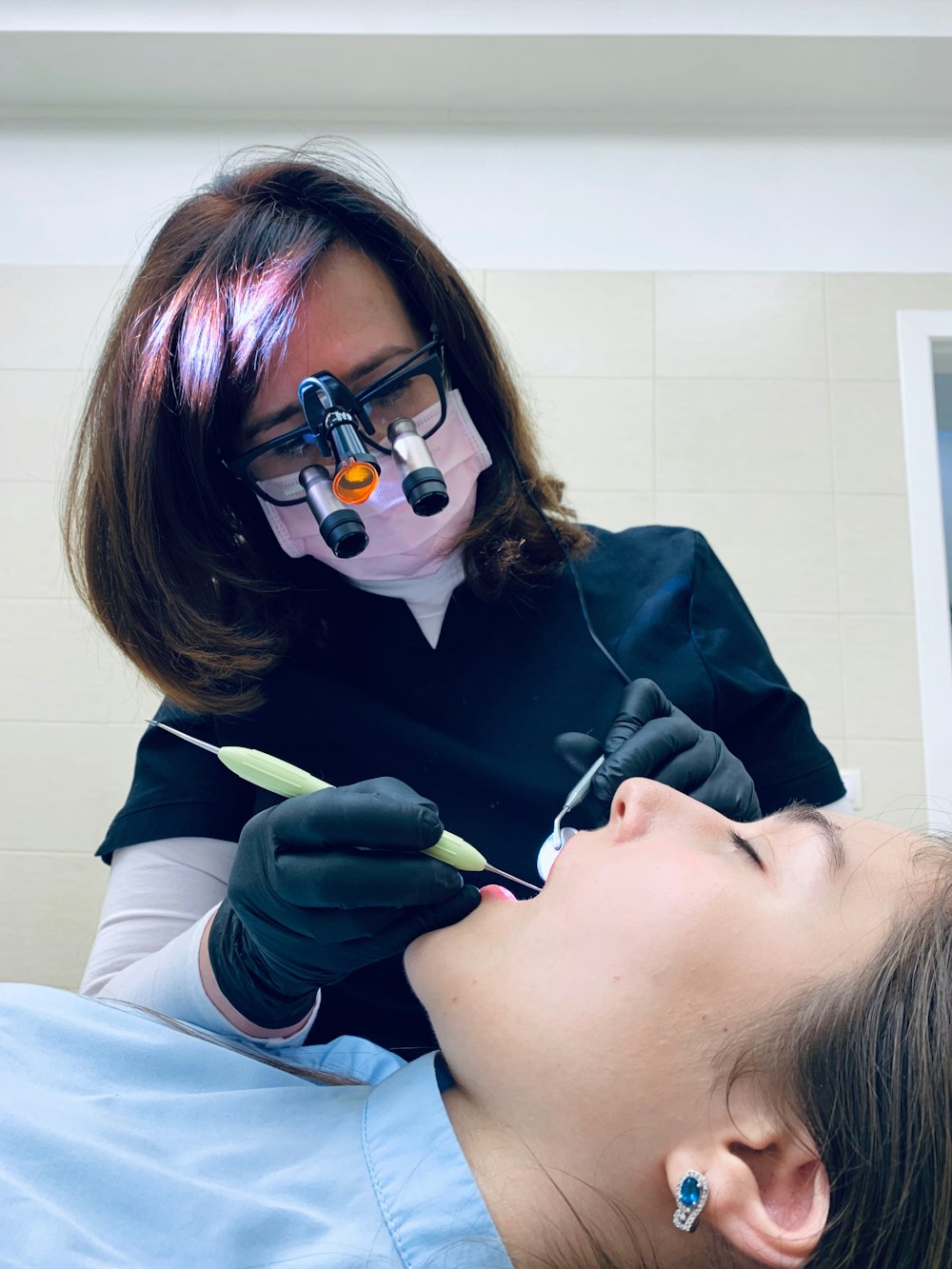 woman holding medical tool on person's mouth