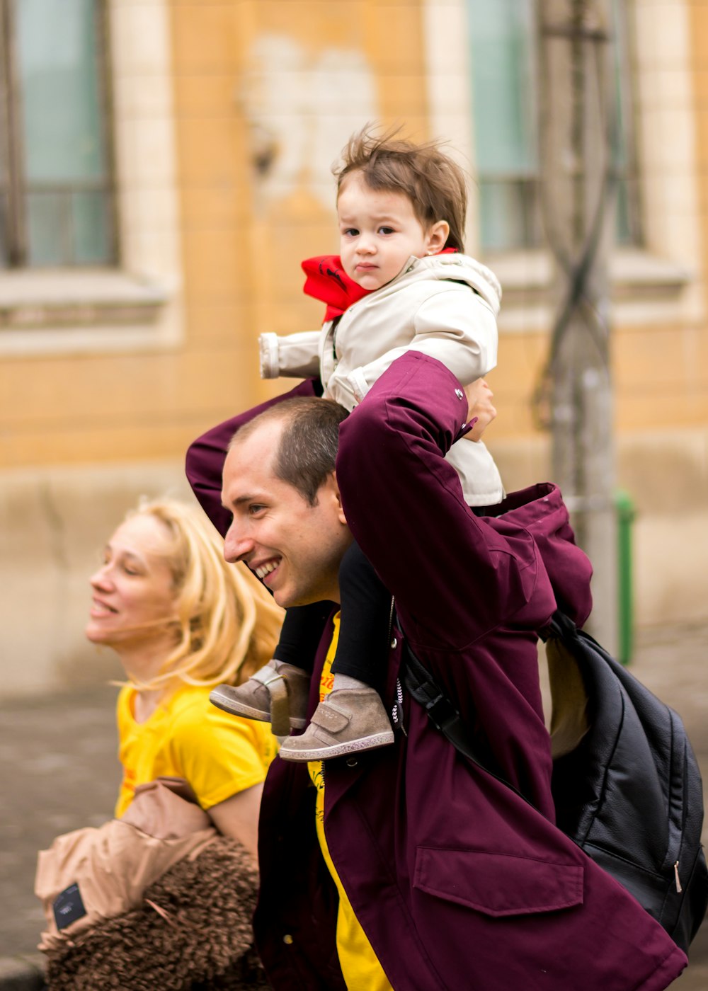 smiling man carrying toddler beside smiling woman