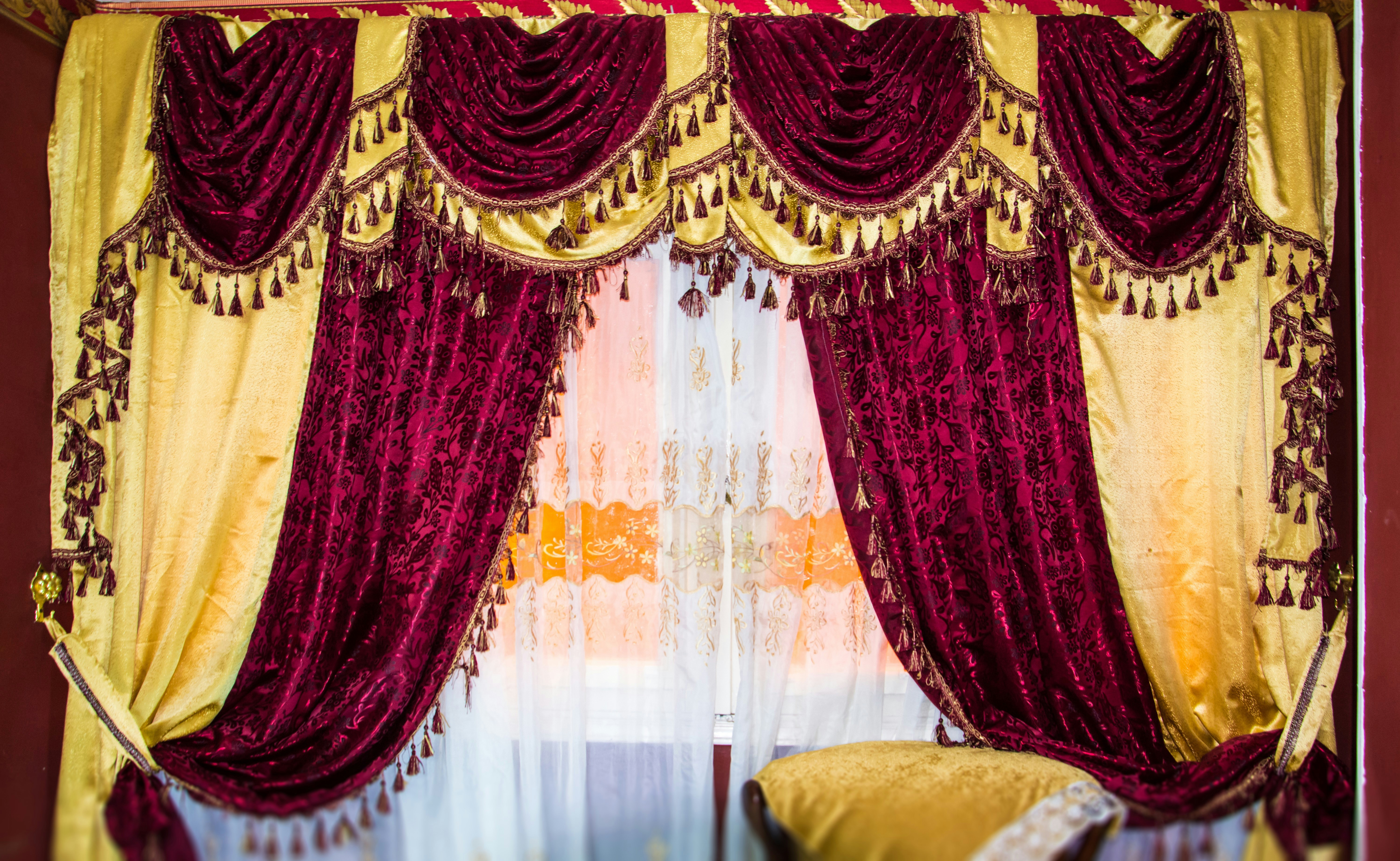 Rich burgundy velvet curtains with gold accents hang elegantly.