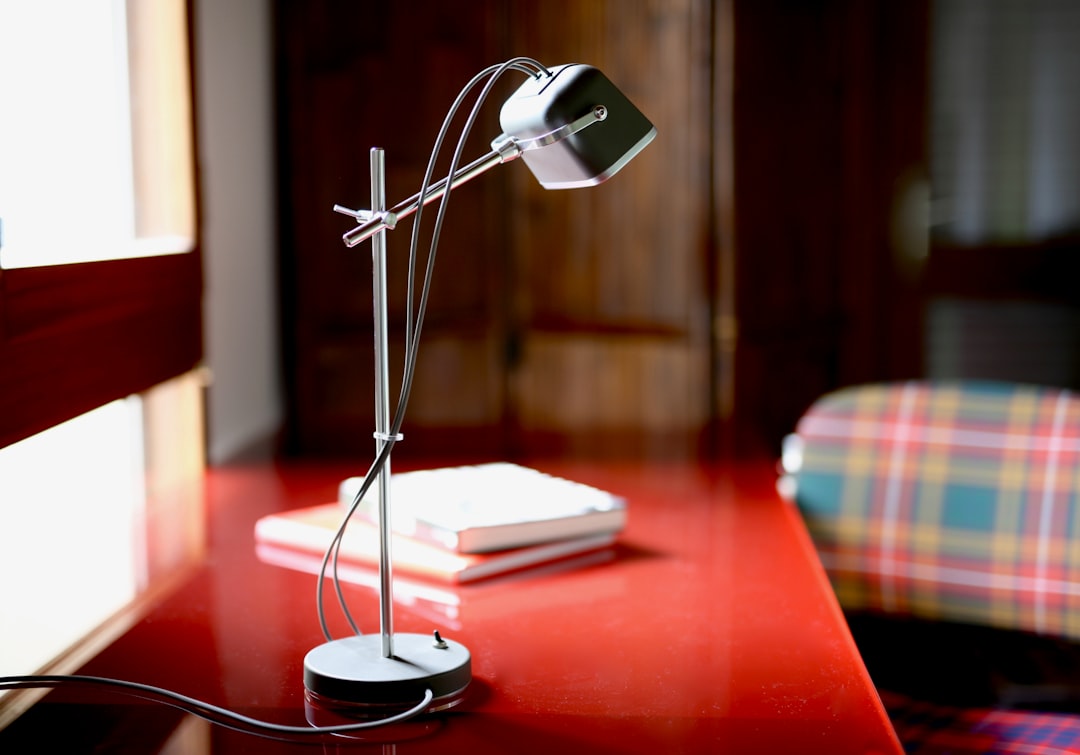 selective focus photo of gray and white articulated table lamp