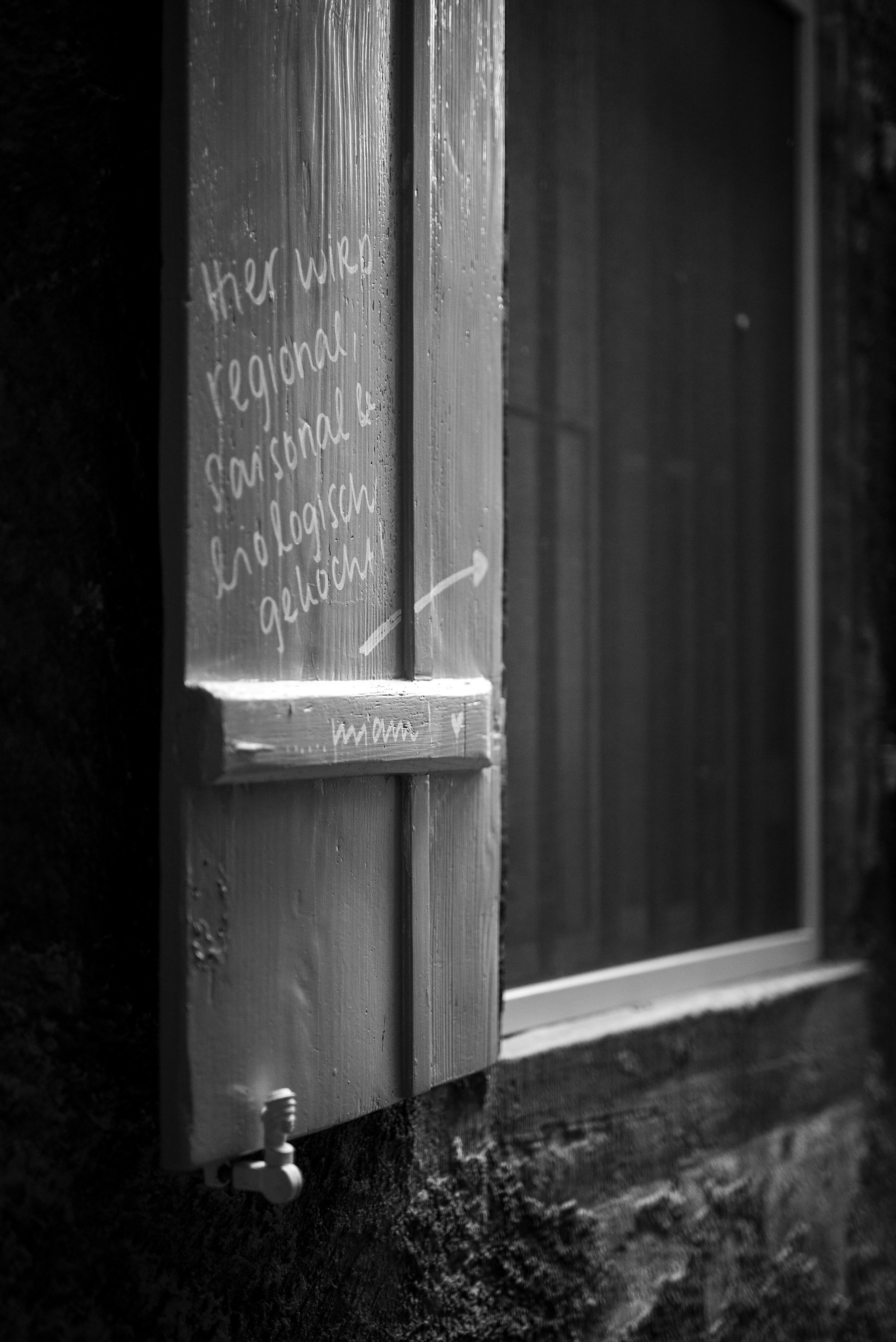 a black and white photo of a window with writing on it
