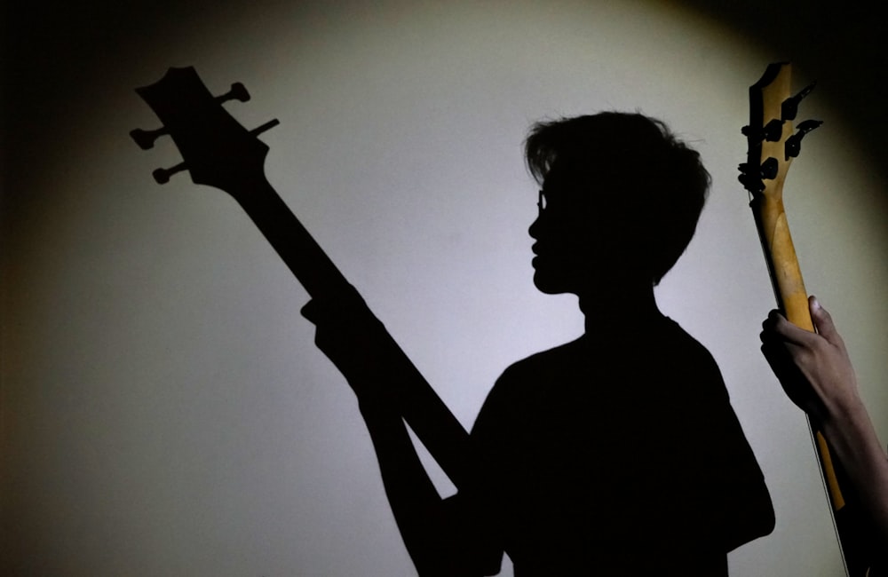 person playing guitar showing shadow