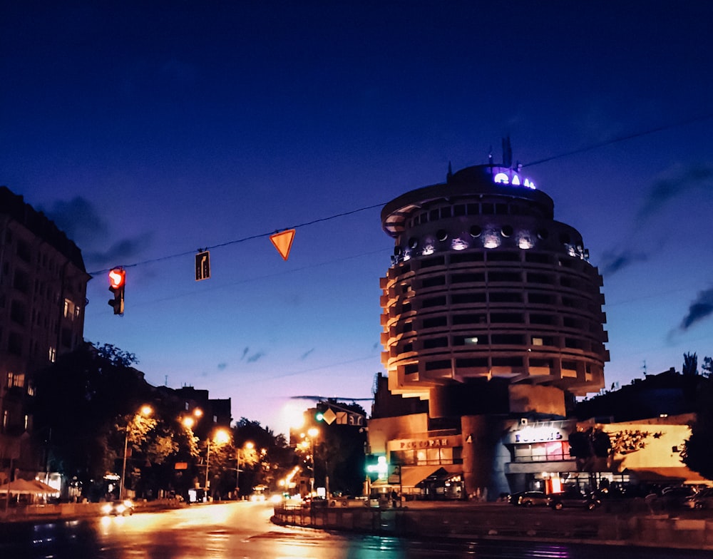 pessoas andando rua perto da estrada e edifícios durante a noite