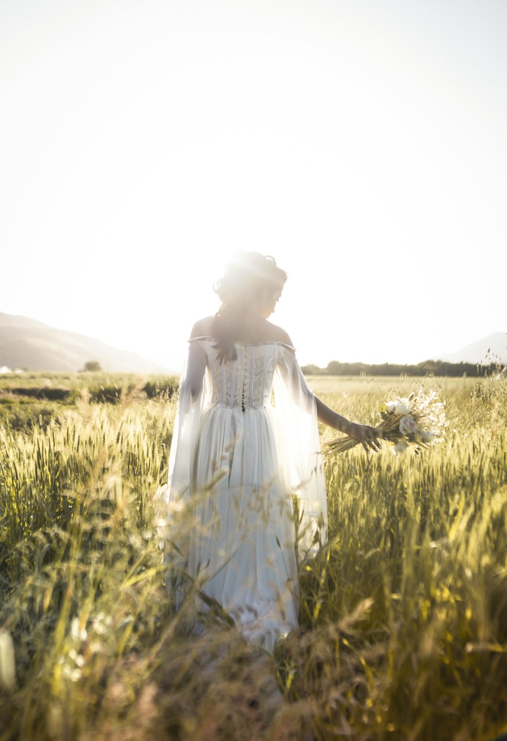 芝生の上で白いドレスを着た女性