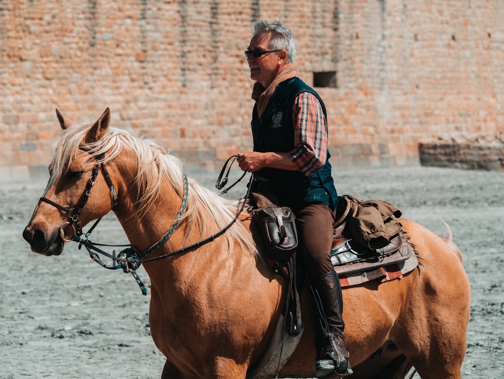 man riding on brown horse