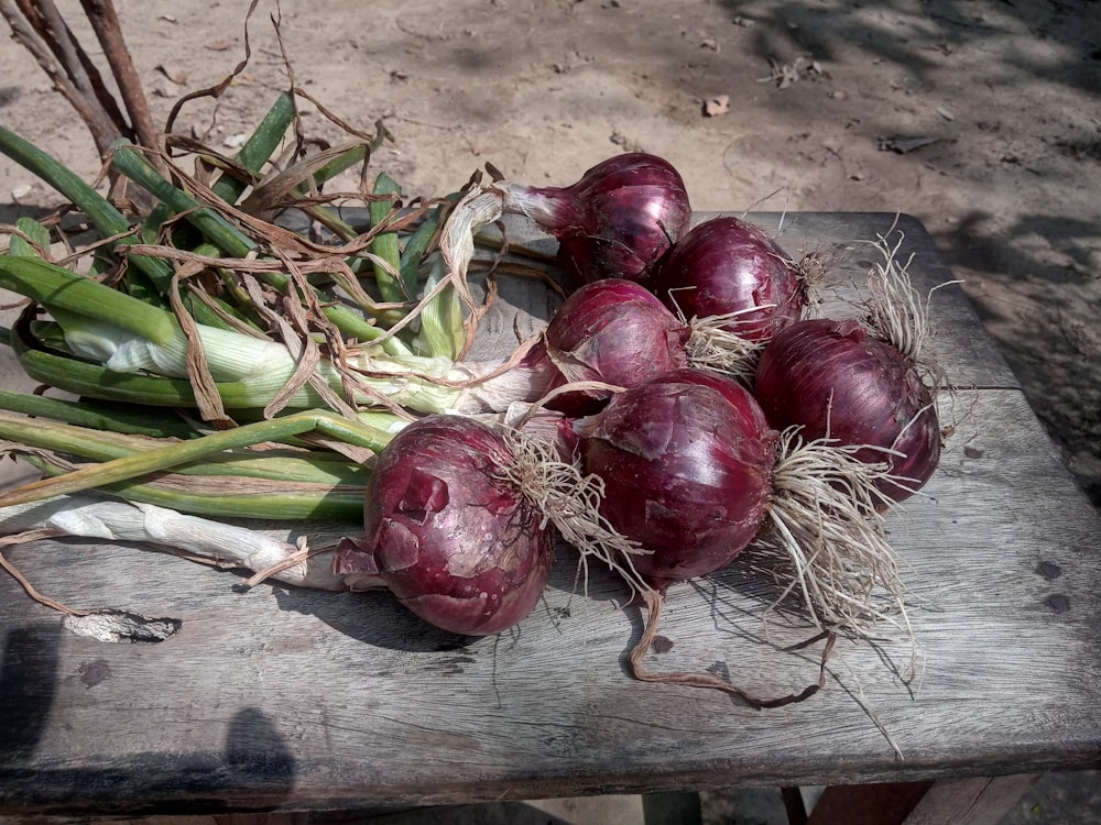 six onion bulbs on wooden table