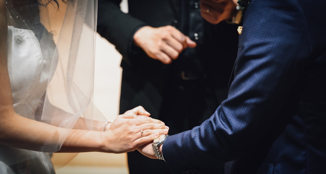 woman holding man's hand during wedding ceremony