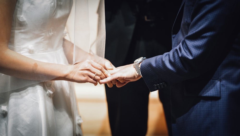 woman inserting ring on man's finger