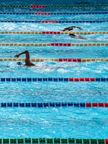 three person swimming on pool