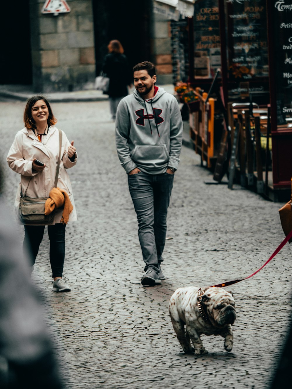 man and woman walking on street near table and chairs