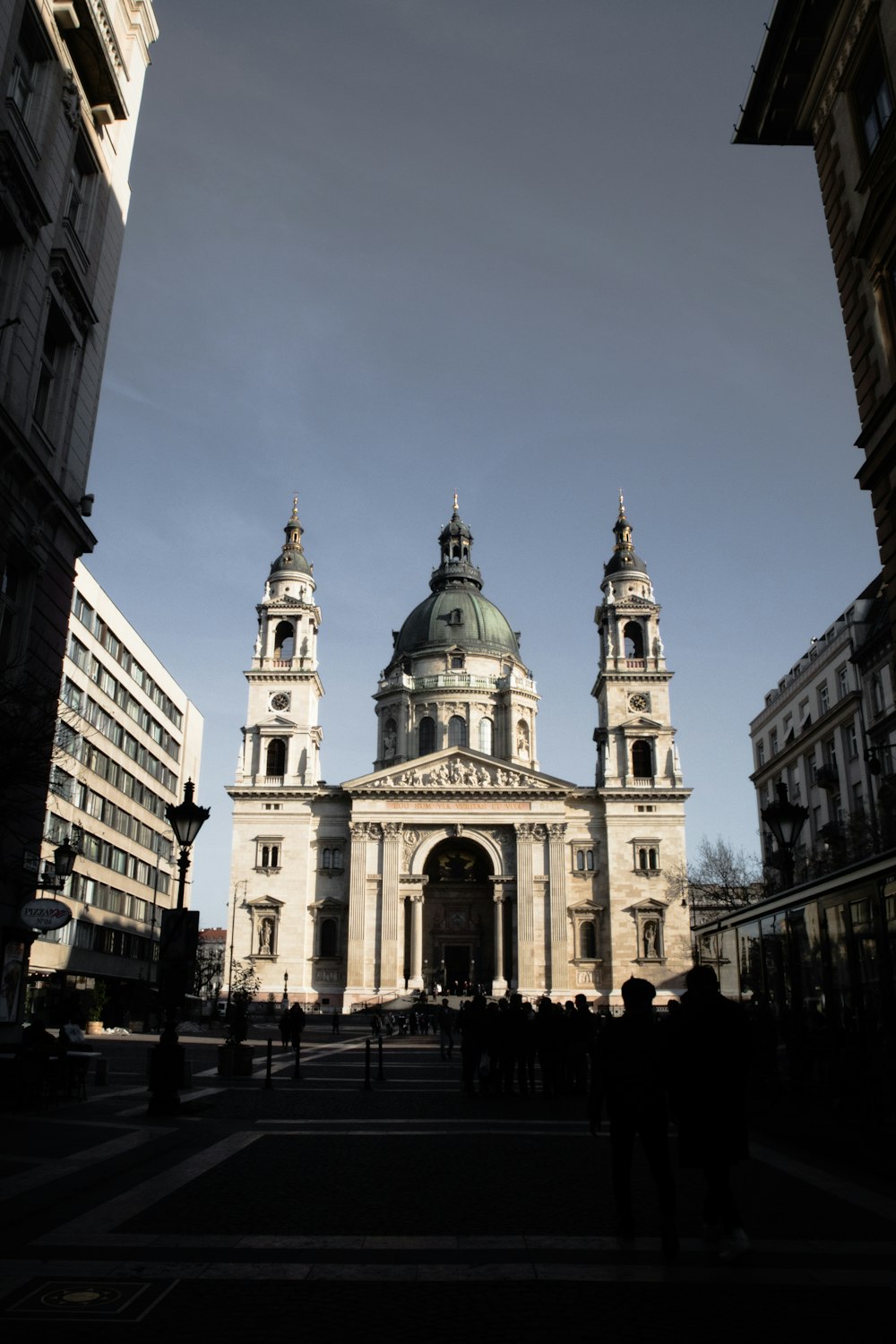 Pessoas caminhando em direção à catedral de concreto branco durante o dia