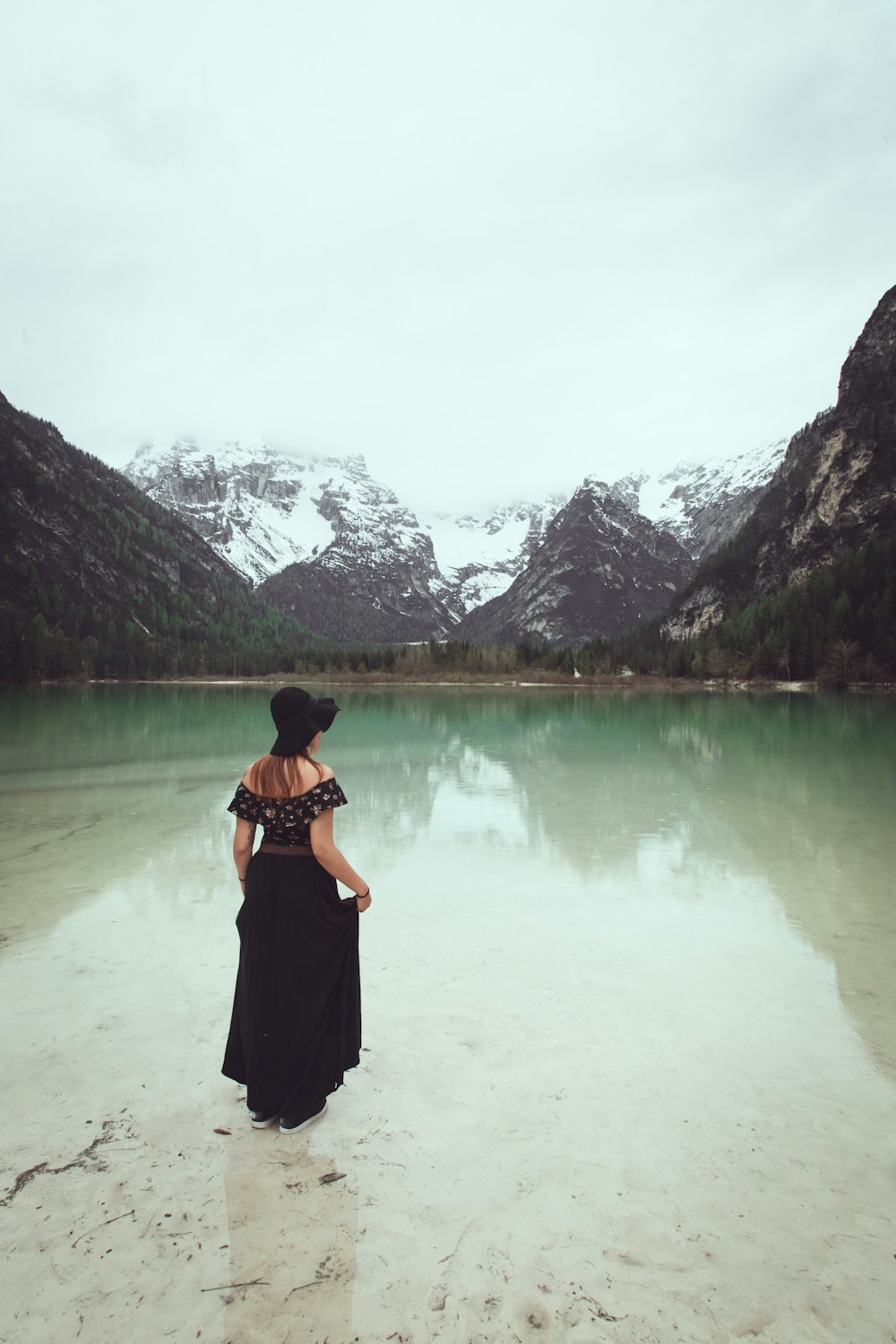 woman standing on calm body of water