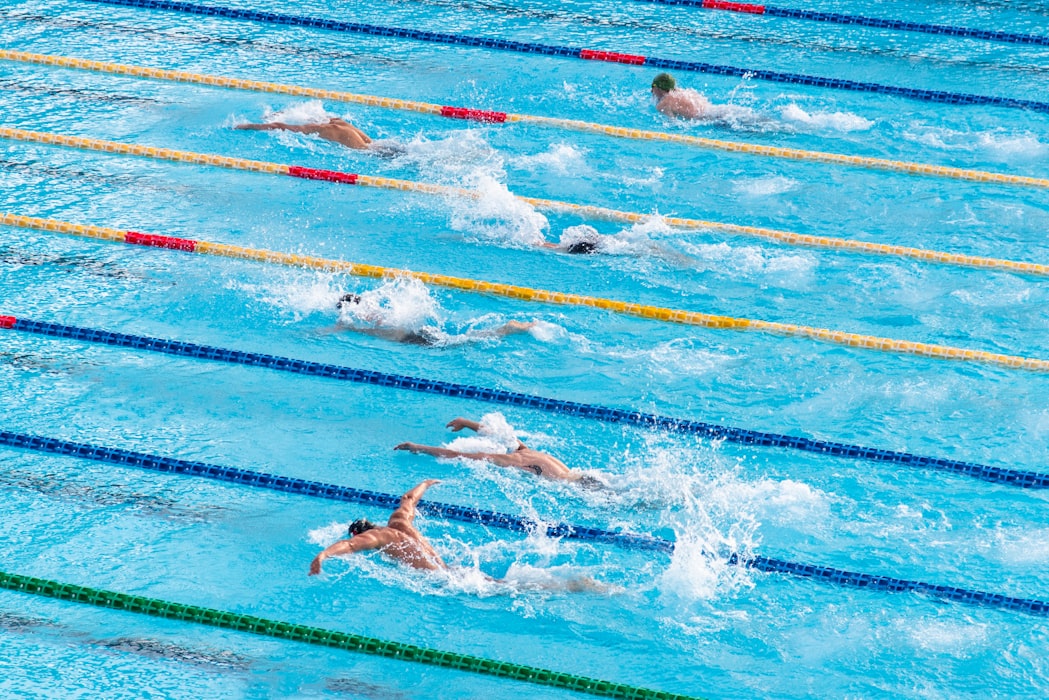 atletas nadando em piscina olímpica