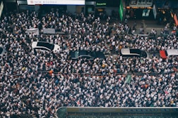 aerial photography of four cars surrounded with people