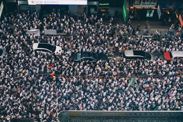 aerial photography of four cars surrounded with people