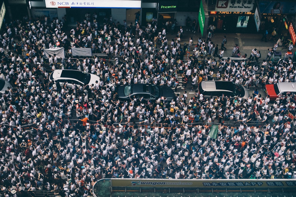 Fotografía aérea de cuatro coches rodeados de gente