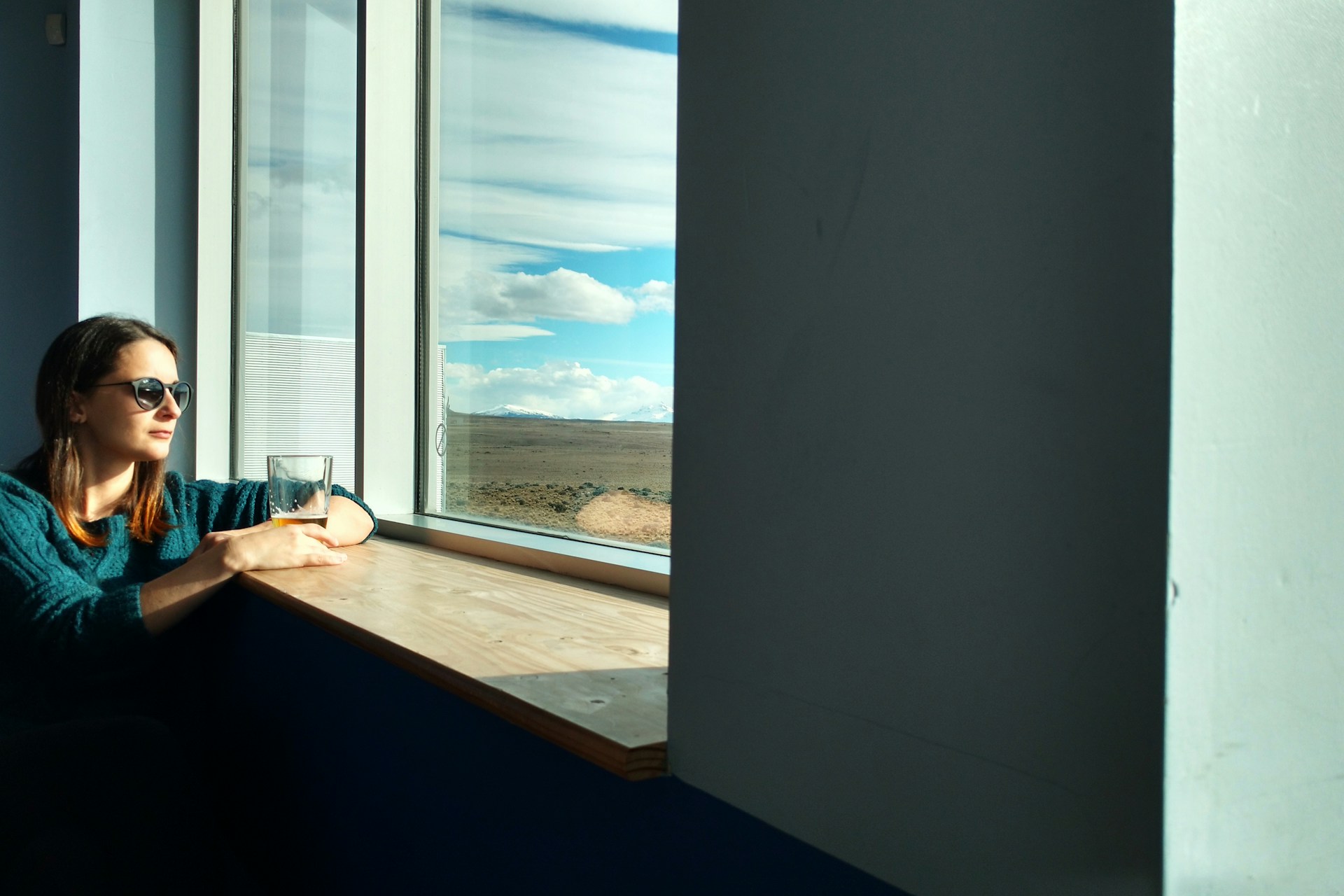 woman sitting beside window while looking outside
